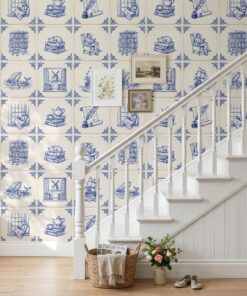 Blue and white azulejo wallpaper with reading scenes on a staircase wall with a white banister