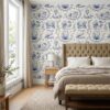 Blue toile wallpaper with bookish scenes behind a tufted headboard in a bedroom