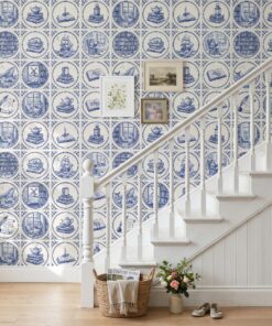 Blue and white delft tile wallpaper with reading scenes on a staircase wall with a white banister