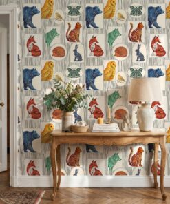 Folk art animal portraits wallpaper behind a carved wooden console table with a linen lamp
