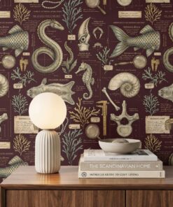 Close-up of maroon wallpaper with naturalist sketches of a sea serpent, mermaid tail, kraken beak, seahorse, nautilus shell and selkie pelt