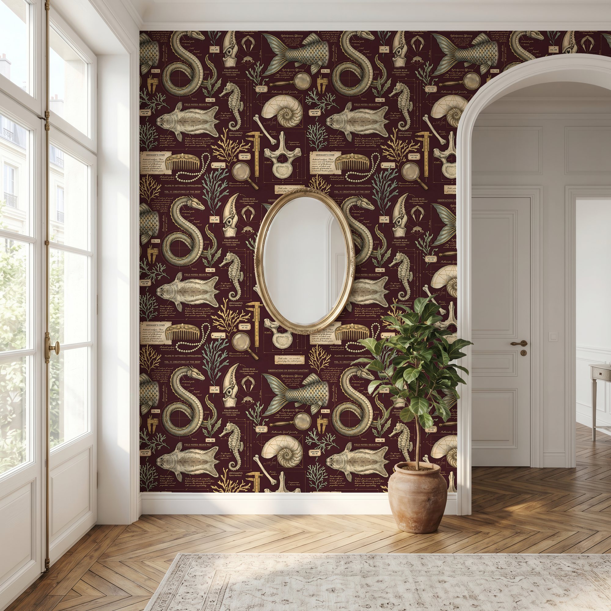 Maroon mermaid wallpaper in an entryway with a gold oval mirror and arched doorway