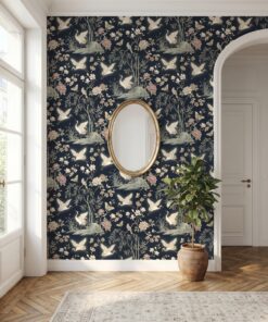 Navy chinoiserie crane wallpaper in an entryway with a gold oval mirror and arched doorway
