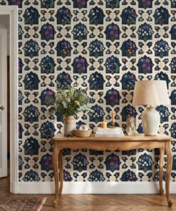 Navy Mughal night garden wallpaper behind a carved wooden console table with a linen lamp