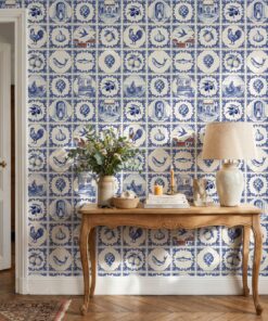 Portuguese tile wallpaper with classic blue azulejos behind a carved wooden console table with a linen lamp