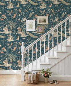 Teal chinoiserie wallpaper with monkeys and peacocks on a staircase wall with a white banister